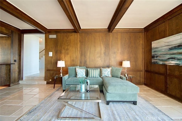 living room featuring stone tile flooring, beamed ceiling, wood walls, and stairs