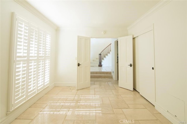 hall with plenty of natural light, crown molding, stairway, and stone tile floors