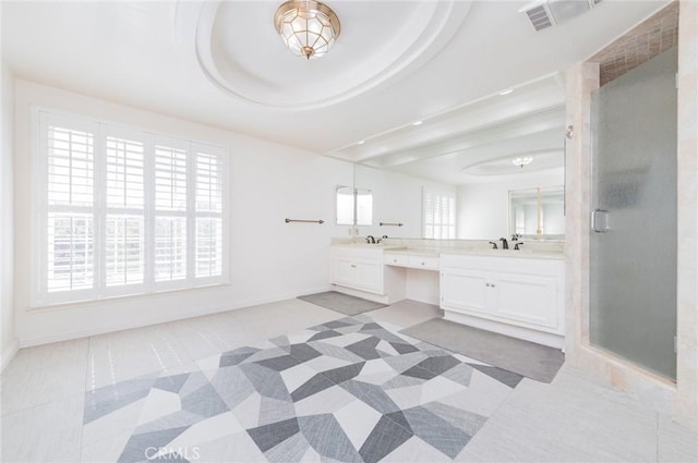 full bath featuring double vanity, a shower stall, visible vents, and a healthy amount of sunlight