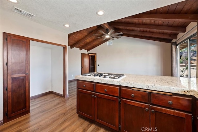 kitchen with vaulted ceiling with beams, light wood finished floors, white gas cooktop, and visible vents