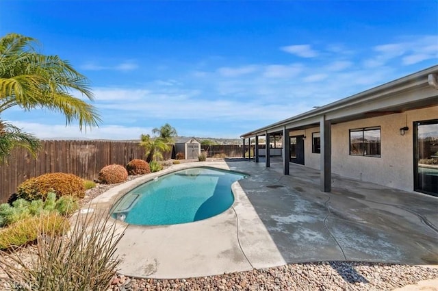 view of swimming pool with a fenced in pool, a patio, a fenced backyard, a storage unit, and an outdoor structure