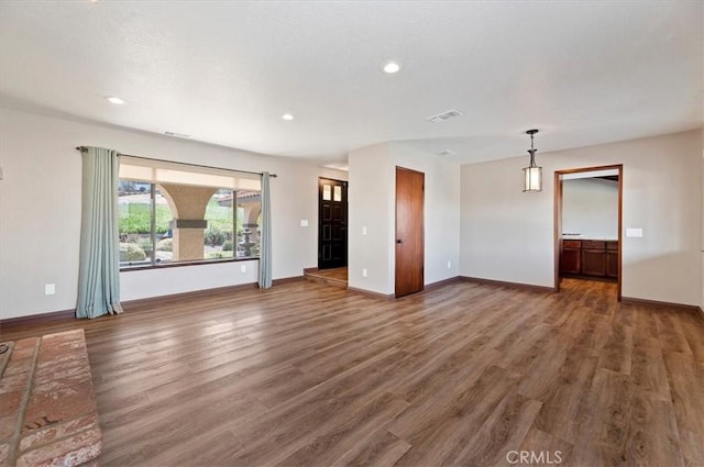 unfurnished living room with visible vents, baseboards, wood finished floors, and recessed lighting