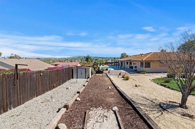 view of yard with an outbuilding, fence, and a storage unit