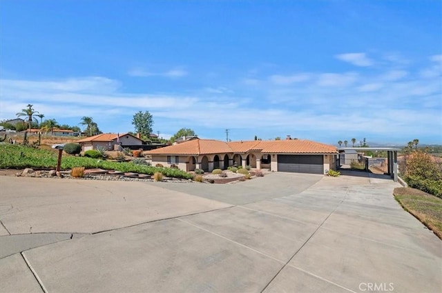 ranch-style house with a garage, a gate, concrete driveway, and a tiled roof