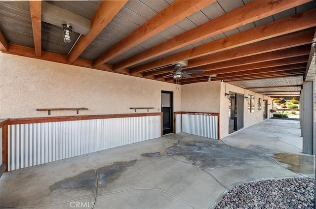 garage with ceiling fan and a textured wall