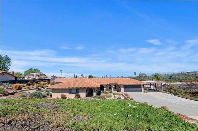 single story home featuring driveway, an attached garage, and a tile roof