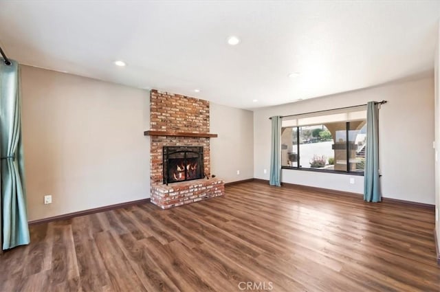 unfurnished living room featuring baseboards, a fireplace, wood finished floors, and recessed lighting