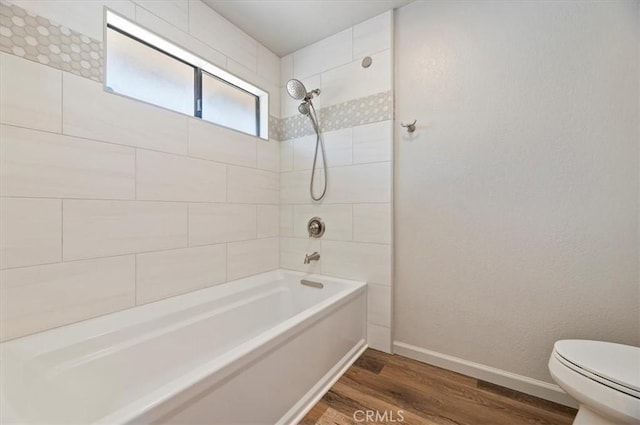 full bathroom with baseboards, shower / tub combination, toilet, and wood finished floors