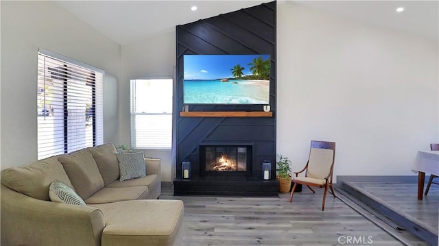 living room with vaulted ceiling, recessed lighting, a fireplace, and light wood finished floors