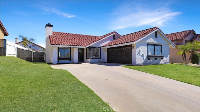 mediterranean / spanish-style home with a tile roof, a front yard, a chimney, a garage, and driveway