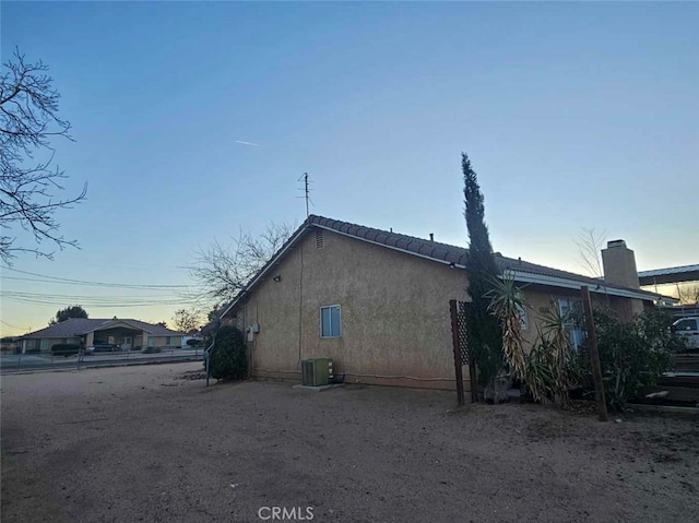 view of property exterior with central air condition unit and stucco siding