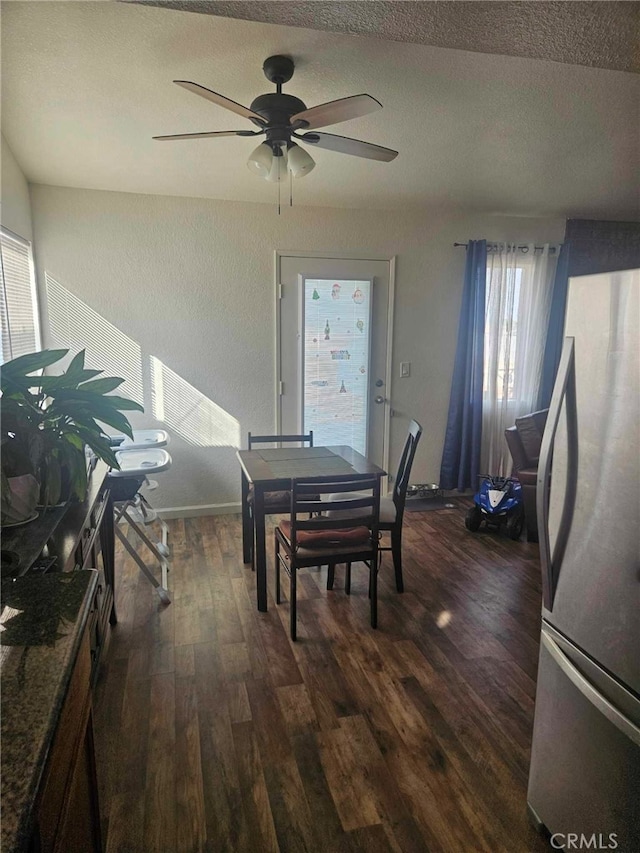 dining space with dark wood-type flooring, a wealth of natural light, ceiling fan, and a textured ceiling