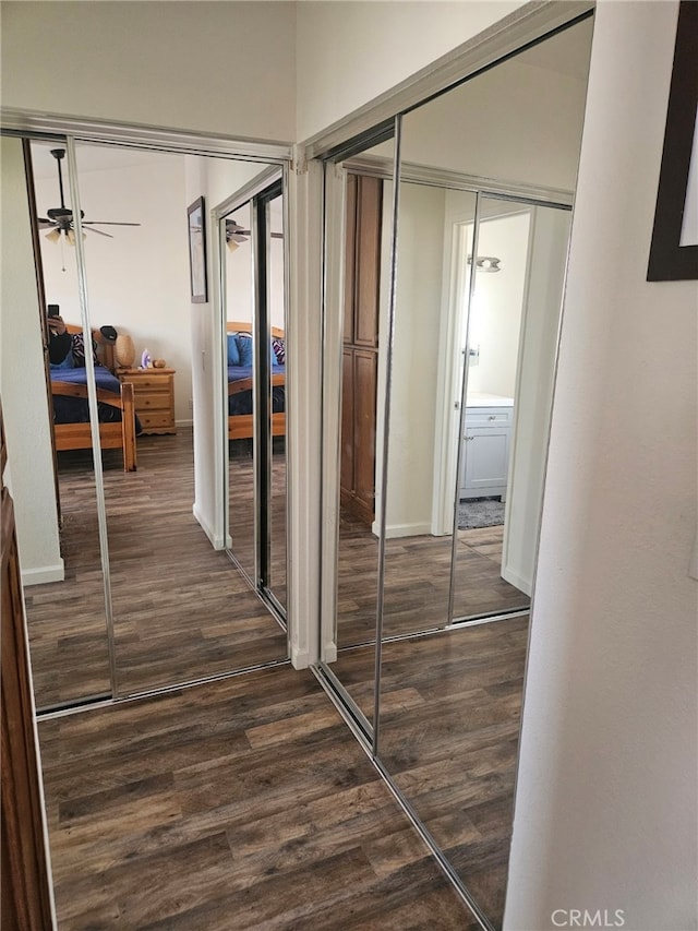 hall featuring baseboards and dark wood-style flooring