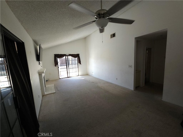 unfurnished living room with visible vents, a ceiling fan, lofted ceiling, a textured ceiling, and carpet floors