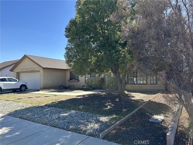 view of front of property featuring driveway, an attached garage, and stucco siding