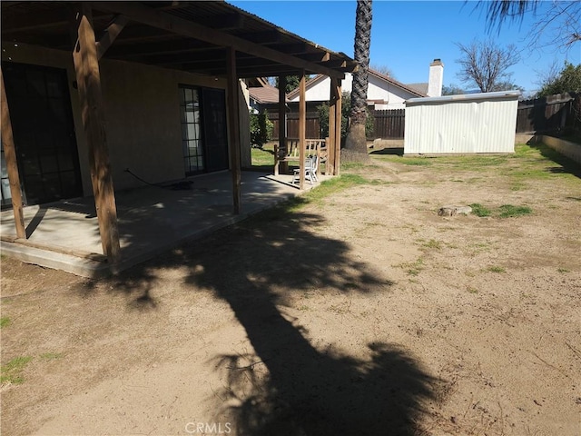 view of yard with a patio, a storage unit, an outdoor structure, and a fenced backyard