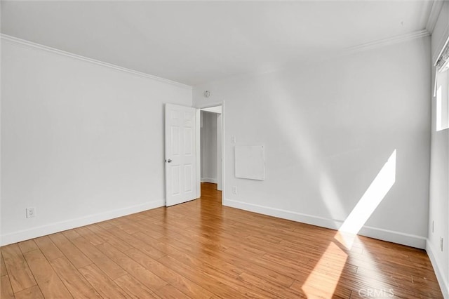 interior space with baseboards, light wood-style flooring, and ornamental molding