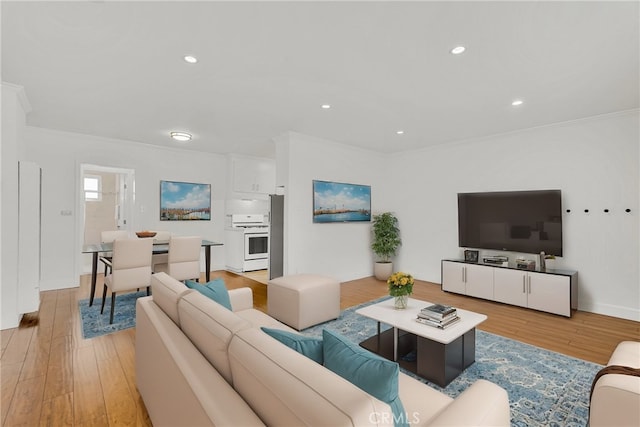 living area with recessed lighting, light wood-style flooring, and ornamental molding