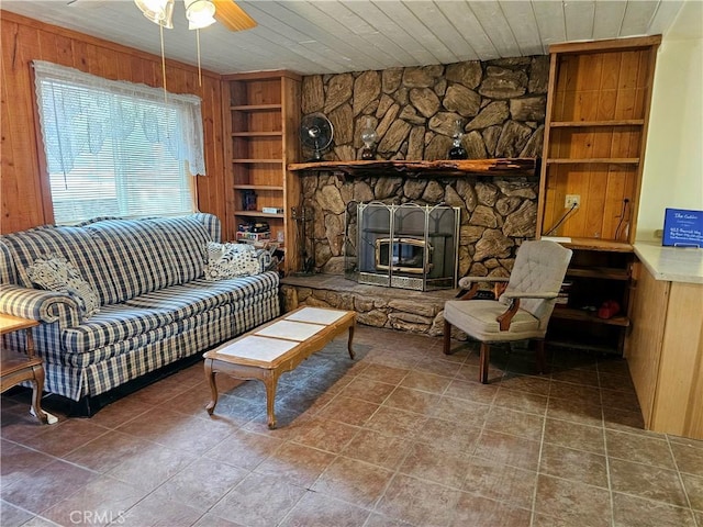 tiled living area with wood walls, built in shelves, wood ceiling, and a ceiling fan