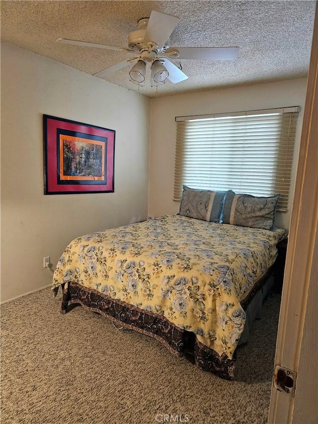 bedroom featuring a textured ceiling, ceiling fan, and carpet flooring