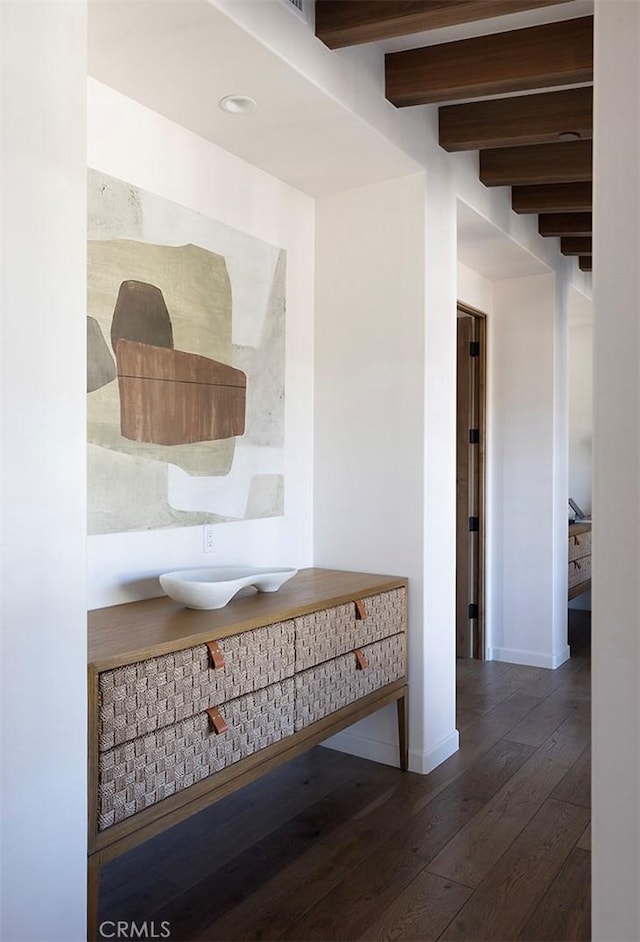 hall with hardwood / wood-style flooring, beamed ceiling, and baseboards