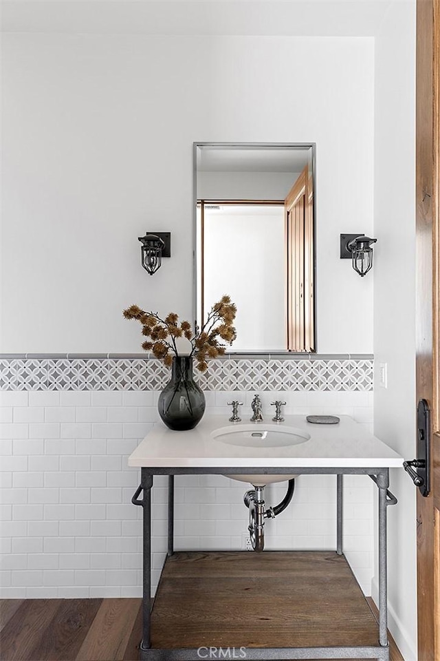 bathroom with tile walls, wainscoting, and a sink