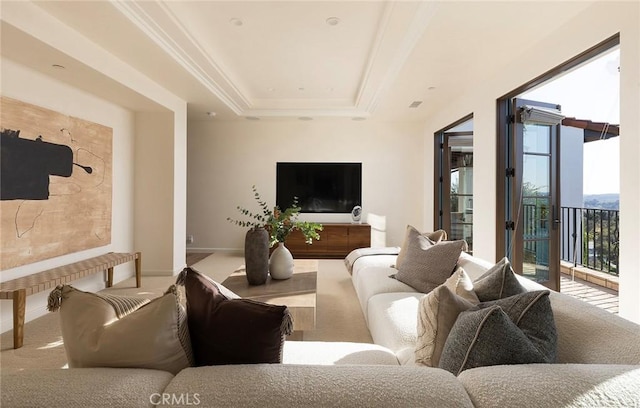 living area featuring a tray ceiling, baseboards, and carpet