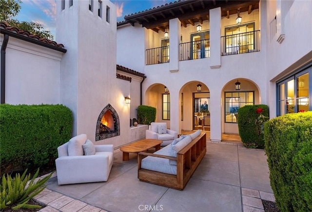 view of patio / terrace featuring a balcony and an outdoor living space with a fireplace