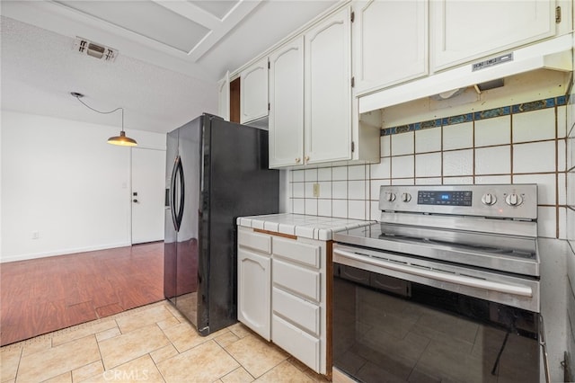 43317 Running Deer Ct, Coarsegold, CA 93614 - kitchen with electric range, tile counters, black fridge with ice dispenser, decorative backsplash, and white cabinets