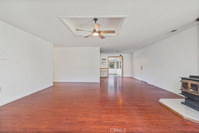 43317 Running Deer Ct, Coarsegold, CA 93614 - unfurnished living room with a wood stove, a ceiling fan, wood finished floors, a textured ceiling, and baseboards