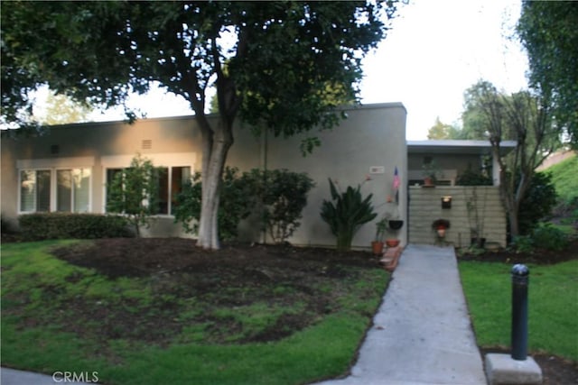 view of front of home featuring a front lawn and stucco siding