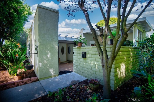 view of home's exterior with a chimney and fence
