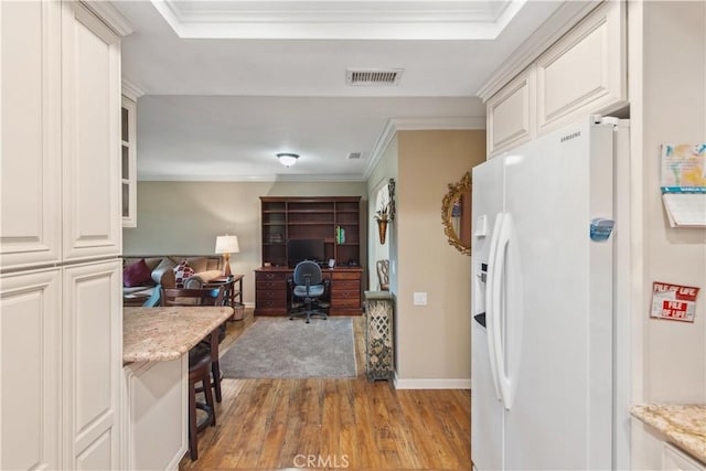 kitchen with ornamental molding, light wood-type flooring, white fridge with ice dispenser, visible vents, and open floor plan
