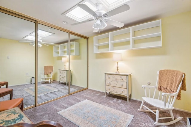 living area featuring ceiling fan, carpet floors, and baseboards