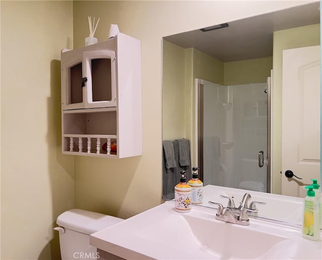 full bath featuring toilet, vanity, and a stall shower