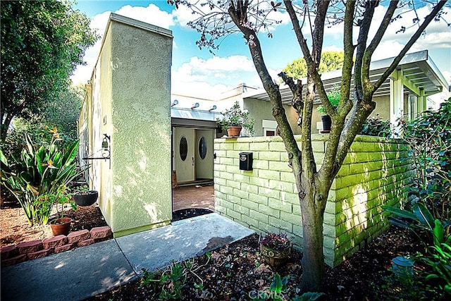 3001C Via Buena Vis Unit C, Laguna Woods, CA 92637 - view of side of property with a chimney and stucco siding