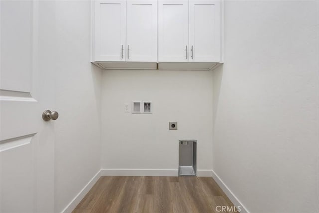 washroom featuring cabinet space, baseboards, wood finished floors, hookup for an electric dryer, and washer hookup