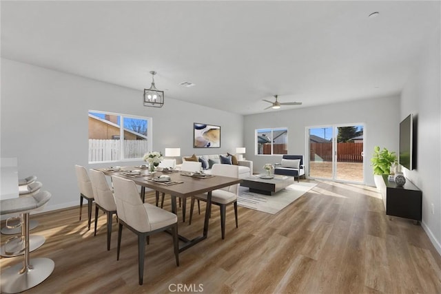 dining area with a notable chandelier, wood finished floors, visible vents, and baseboards