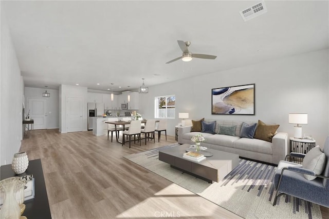 living area featuring recessed lighting, visible vents, ceiling fan, and light wood-style flooring