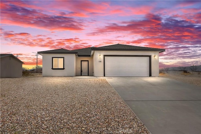 view of front of home featuring a garage, concrete driveway, and stucco siding