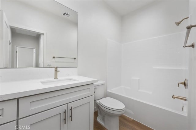 full bathroom featuring shower / bathtub combination, toilet, wood finished floors, visible vents, and vanity