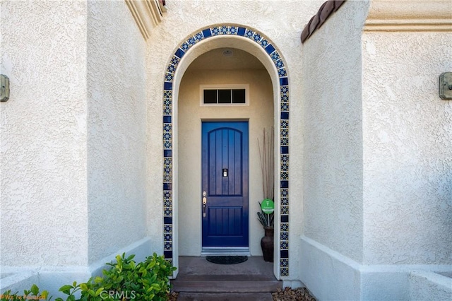 entrance to property featuring stucco siding