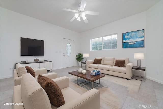 living area featuring ceiling fan and baseboards