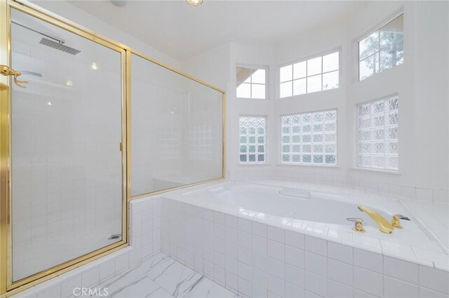 full bath with marble finish floor, a stall shower, and a bath