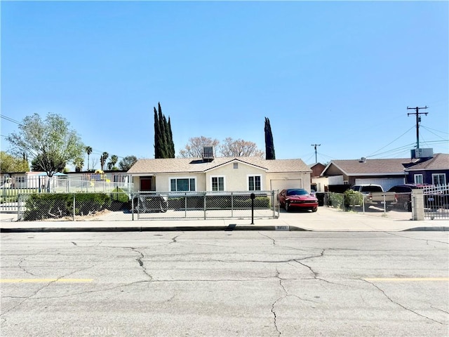 view of front of home with a fenced front yard and concrete driveway