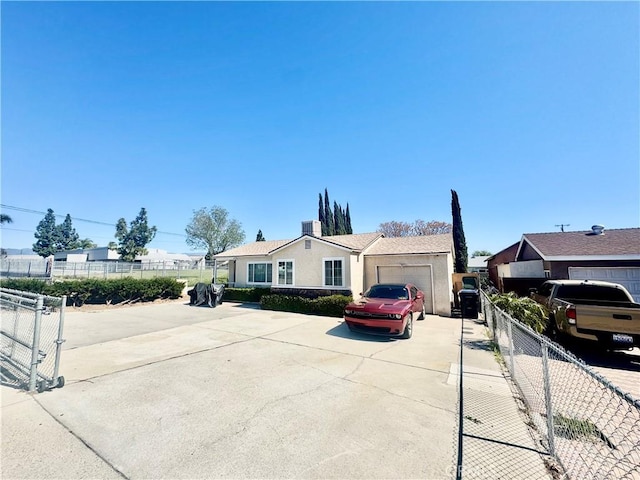 view of front of house with stucco siding, an attached garage, concrete driveway, and fence