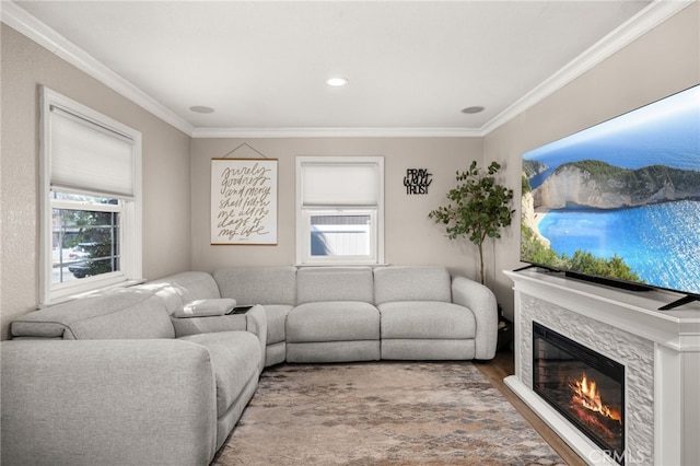 living area with a wealth of natural light, a stone fireplace, and ornamental molding