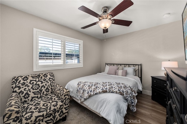 bedroom with a ceiling fan, wood finished floors, and baseboards