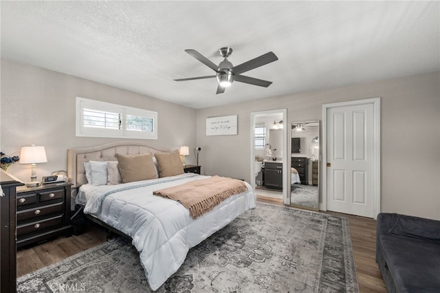 bedroom with a textured ceiling, ensuite bathroom, ceiling fan, and wood finished floors