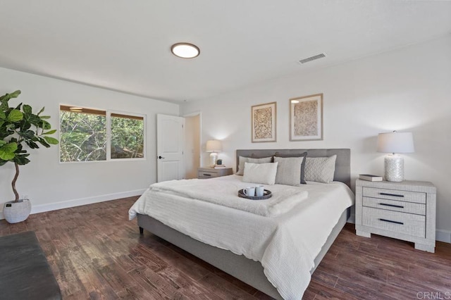 bedroom with visible vents, baseboards, and wood finished floors